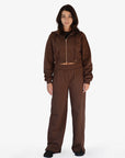 A model wearing a matching brown cropped zip-up hoodie and wide-leg sweatpants set, photographed against a plain white studio background.